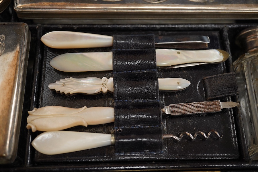 A Victorian leather vanity case with fitted interior to include white metal mounted glass bottles and mother of pearl mounted implements, with key, 27.5cm wide. Condition - fair, handle broken